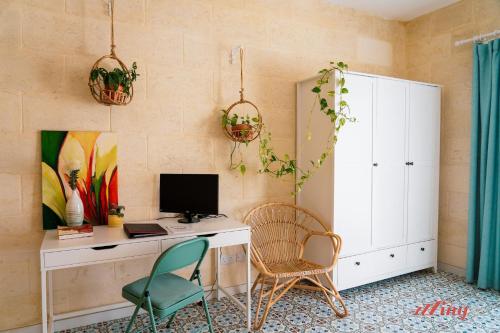 a room with a desk with a computer and two chairs at A remarkable Eco Home in Gozo in Nadur