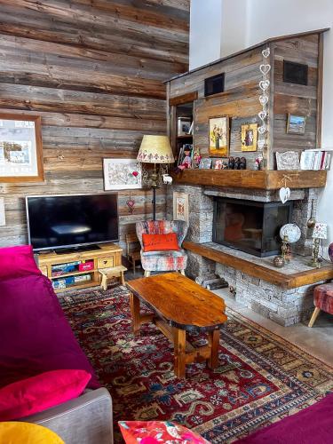 un salon avec un canapé et une cheminée dans l'établissement Chalet La Savoyarde, à Peisey-Nancroix