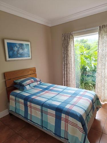 a bedroom with a bed and a window at Wave Echo in Plettenberg Bay