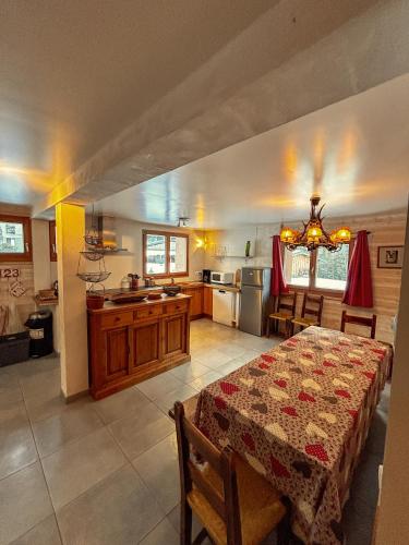 a kitchen and a dining room with a table with a table at Chalet La Savoyarde in Peisey-Nancroix