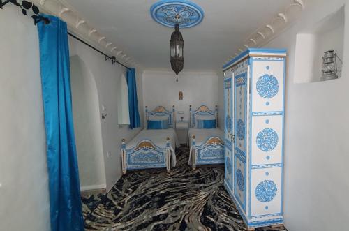 舍夫沙萬的住宿－Dar La Aicha，一间卧室配有两张蓝色和白色的床
