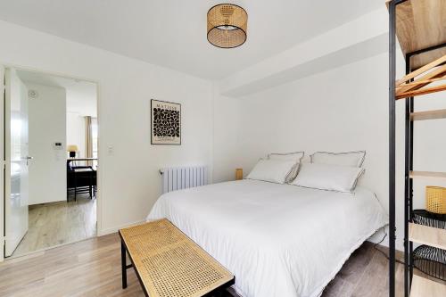 Un dormitorio blanco con una cama y una mesa. en La Résidence Alpha Viroflay 302 - Duplex 2 chambres - 5 pers, en Viroflay