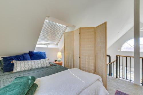 Un dormitorio con una cama con almohadas azules y una ventana en Dreamy Hudson Valley Cottage with State Park Views, en Garrison