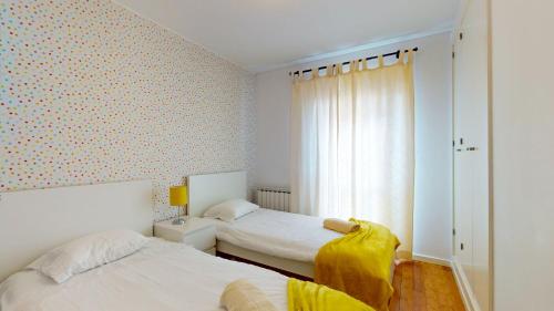 1 dormitorio con 2 camas y ventana en Happy Building By GW Holidays, en Lisboa