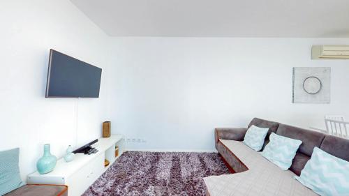 a living room with a couch and a flat screen tv at Happy Building By GW Holidays in Lisbon
