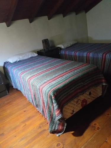Una cama con una manta de colores en una habitación en Chalet Mitaluya en Miramar