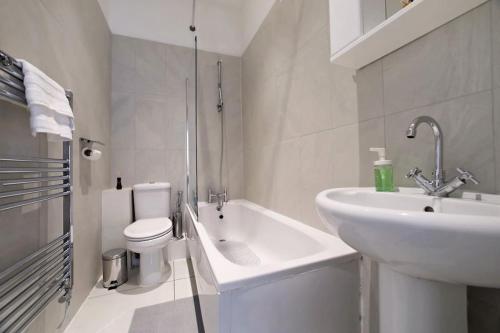 Baño blanco con lavabo y aseo en LittleVenice modern one bed flat, en Londres