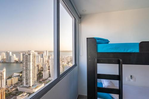 ein Schlafzimmer mit einem Etagenbett und einem großen Fenster in der Unterkunft 41st Fl Beach Condo in Bocagrande in Cartagena de Indias