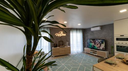 a living room with a potted plant and a television at be Unforgettable Apartment in Faro