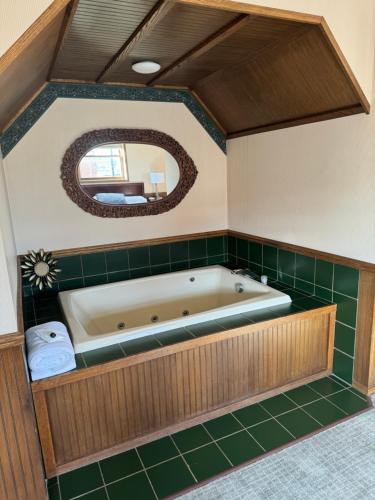 a bath tub in a bathroom with green tiles at Fenway House Hotel in Fennimore