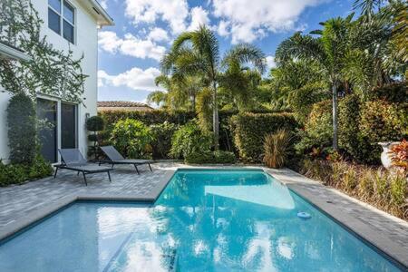 a swimming pool in front of a house at VILLA MAGNOLIA-with heated pool-by VIAC in Fort Lauderdale