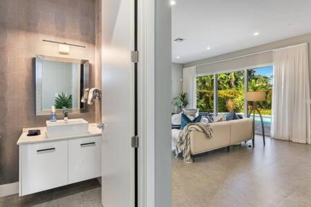 a bathroom with a sink and a living room at VILLA MAGNOLIA-with heated pool-by VIAC in Fort Lauderdale