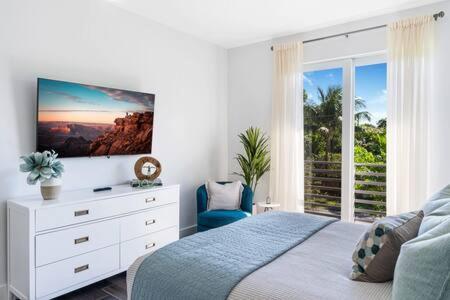 a bedroom with a bed with a dresser and a window at VILLA MAGNOLIA-with heated pool-by VIAC in Fort Lauderdale