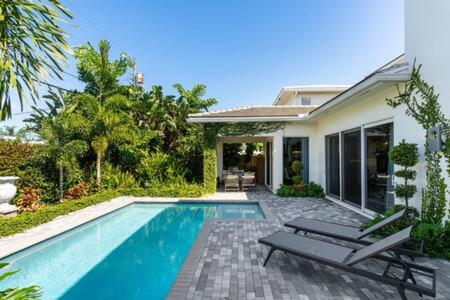 a house with a swimming pool in front of a house at VILLA MAGNOLIA-with heated pool-by VIAC in Fort Lauderdale