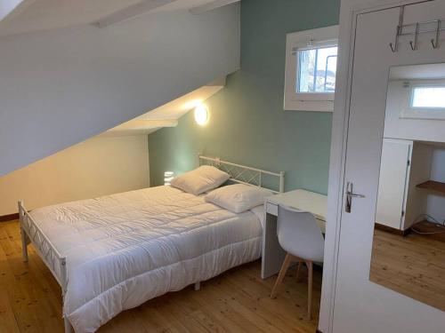 une chambre avec un lit, un bureau et une fenêtre dans l'établissement L'Aréna - Logement cosy proche des arènes, à Nîmes