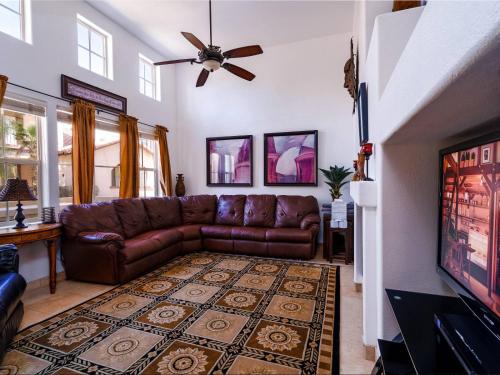 a living room with a brown leather couch and a tv at POOL SIDE, with free WiFi and GOLF PASS in La Ponderosa