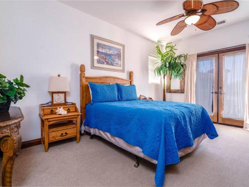 a bedroom with a blue bed and a ceiling fan at Pool Side with free WiFi and Golf Pass in San Felipe