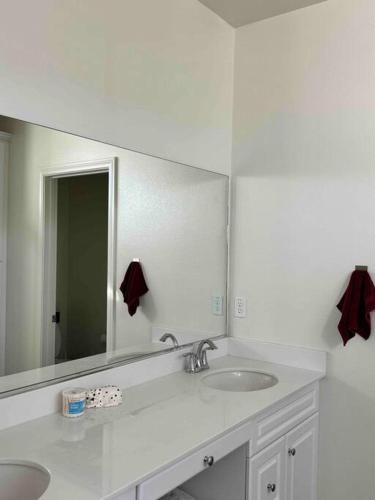 a bathroom with two sinks and a large mirror at 3 Bedroom Townhome with Large Living Area in Downey