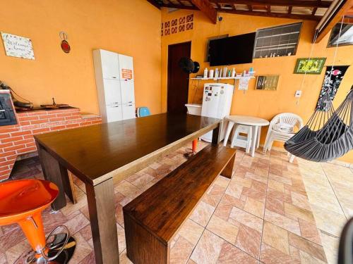 a kitchen with a wooden table in a room at Casa de Campo Atibaia c/ Piscina Aquecida in Atibaia
