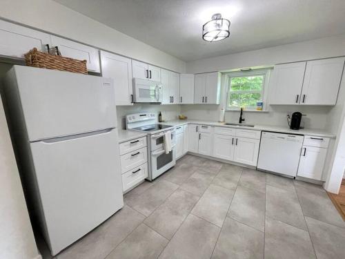 ガンセボートにある2023 Remodeled 4bed/2bath Home!のキッチン(白いキャビネット、白い冷蔵庫付)