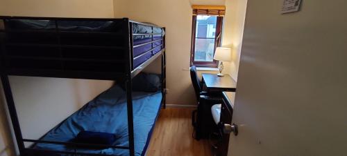 ein Schlafzimmer mit einem Etagenbett, einem Schreibtisch und einem Schreibtisch in der Unterkunft Wembley house in London