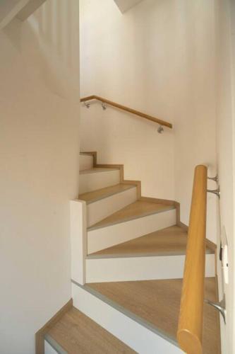 a staircase in a house with a wooden railing at Da Elda in Belluno