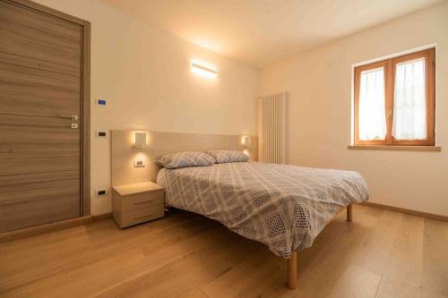 a bedroom with a bed and a window at Da Elda in Belluno