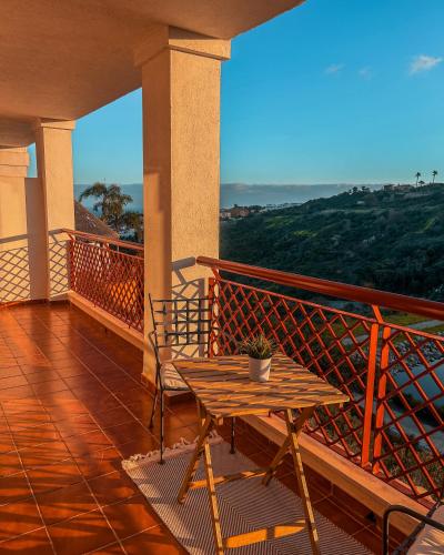 a table and chair on a balcony with a view at Albatross Golf Suite Alcaidesa in Alcaidesa