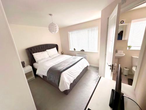 a small bedroom with a bed and a bathroom at Ensuite Room with free parking 