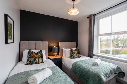 1 dormitorio con 2 camas y ventana en Kist Accommodates - Belmont Dene, en Knaresborough