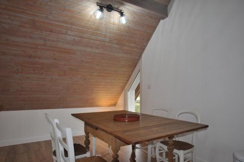 a dining room with a wooden table and chairs at L'Hirondelle - Charming flat - in Blotzheim