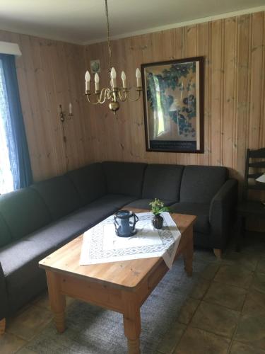 a living room with a couch and a coffee table at Rønlund Hyttepark, Midgard in Ron