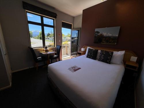 ein Hotelzimmer mit einem großen Bett und einem Balkon in der Unterkunft Snowhaven in Ohakune