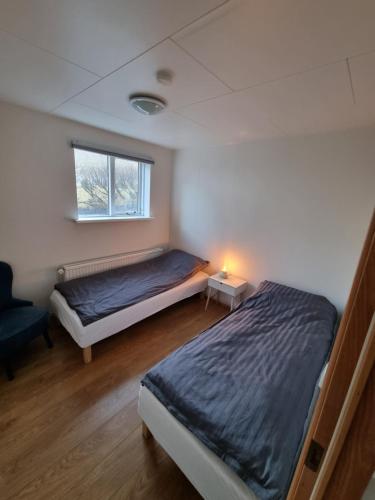a bedroom with two beds and a window at K15 Apartment in Vestmannaeyjar