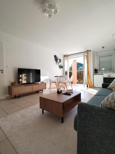 uma sala de estar com um sofá e uma mesa de centro em t2 spacieux très bien place em Gagnac-sur-Garonne