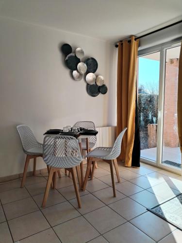 uma sala de jantar com mesa e cadeiras e um coração na parede em t2 spacieux très bien place em Gagnac-sur-Garonne