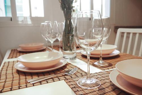 a table with wine glasses and plates on it at Breathtaking Sunsets Flat in Las Palmas de Gran Canaria