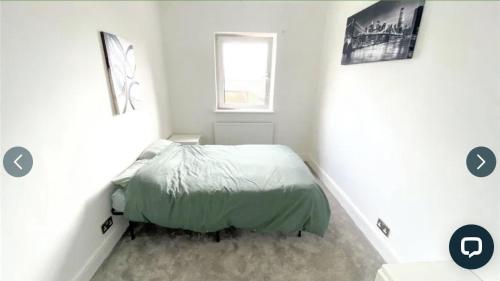 a bedroom with a bed in a white room at 4 bedroom property close to the Harry Potter studio and Watford junction in Leavesden Green