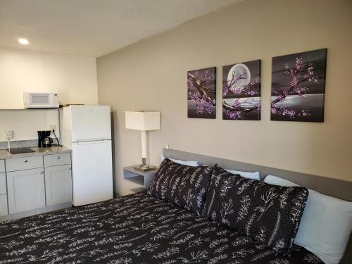 a bedroom with a bed and a white refrigerator at Budget Inn Durango in Durango