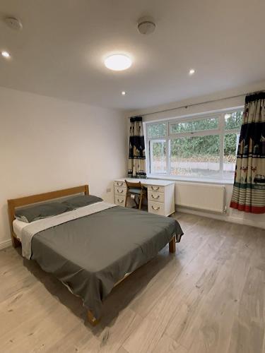 a bedroom with a bed and a desk and a window at Cloud Green apartment in Canley