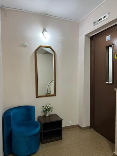a blue chair in a room with a mirror at Hotel Han Krum in Targovishte