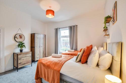 um quarto com uma cama com um cobertor laranja em Stylish & Vibrant 2 BR Retreat Manchester em Manchester