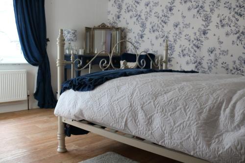 a bedroom with a bed and a mirror at Hectors house in Ormesby Saint Michael