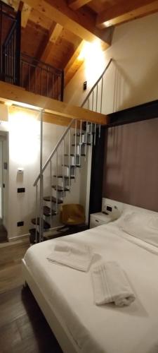a bedroom with a white bed and a staircase at Agriturismo Le Valli in Liedolo