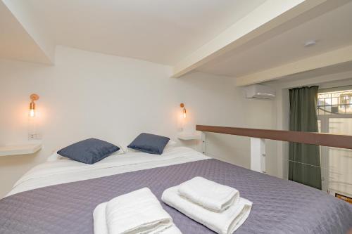 una camera da letto con un letto e asciugamani di Barbara's house - Milano Navigli - 2 km from Duomo a Milano