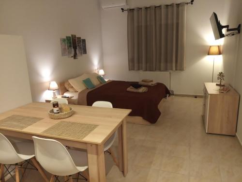 um quarto com uma cama, uma mesa e cadeiras em Studio Gaia em Volos