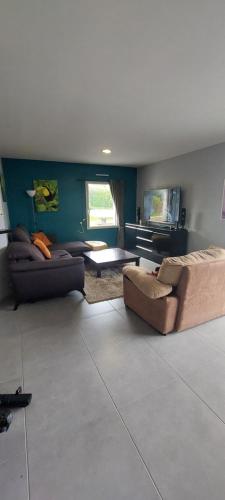 a living room with two couches and a table at Maison de Vacances in Locronan