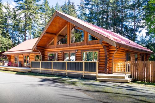 a log cabin with a gambrel roof at Riverbend Cottage & RV Resort in Parksville
