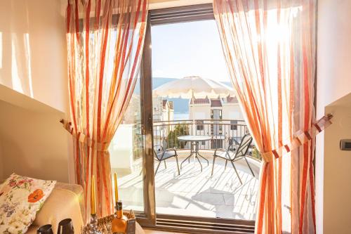 a room with a balcony with a view of a patio at Sunny Portside Apartment in Ðenovići