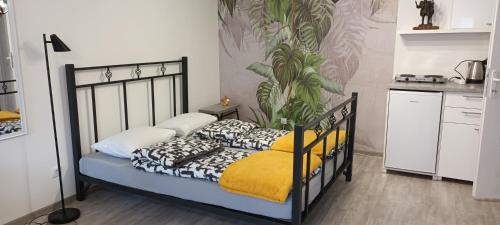 een slaapkamer met een bed met een plant aan de muur bij Flora Novi Sad in Novi Sad